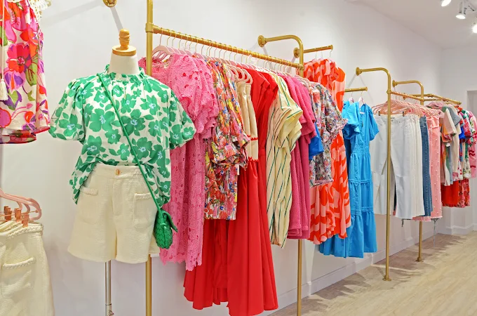 Inside Confeetti Boutique — colorful dresses on gold racks